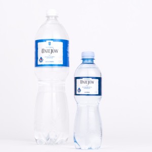 Dwie butelki z wodą, po lewej większa butelka
